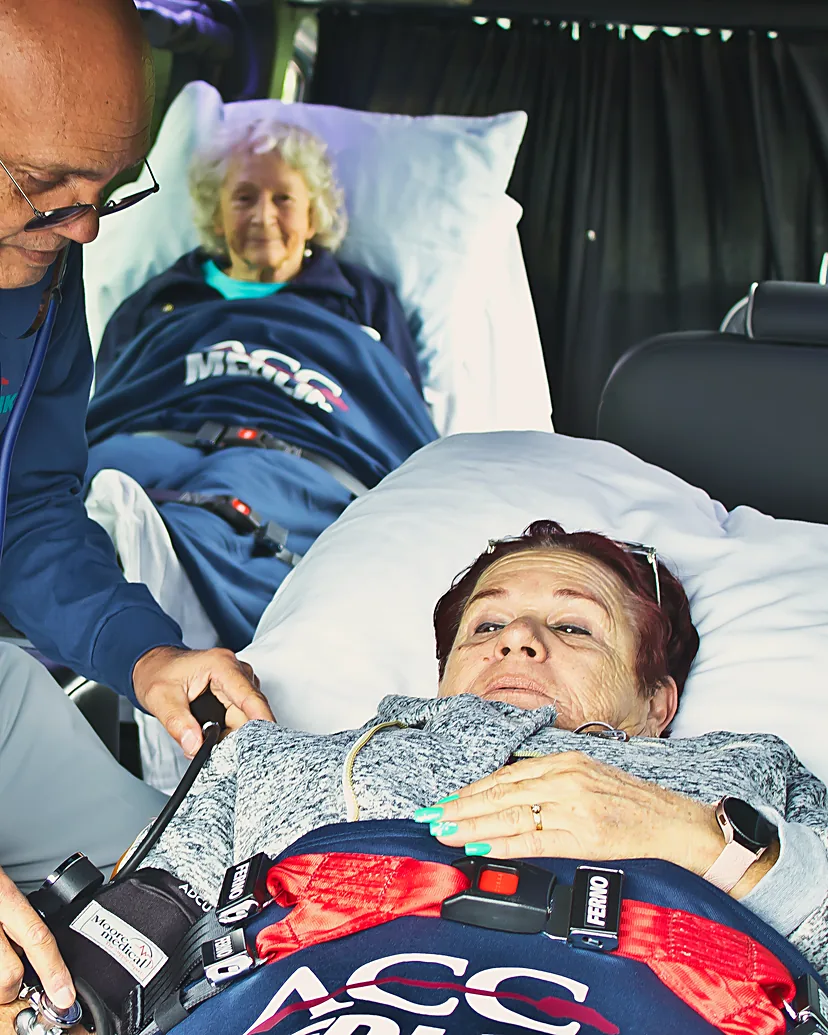 ACC Medlink medical attendant checking a patient's blood pressure in a real bed during the trip