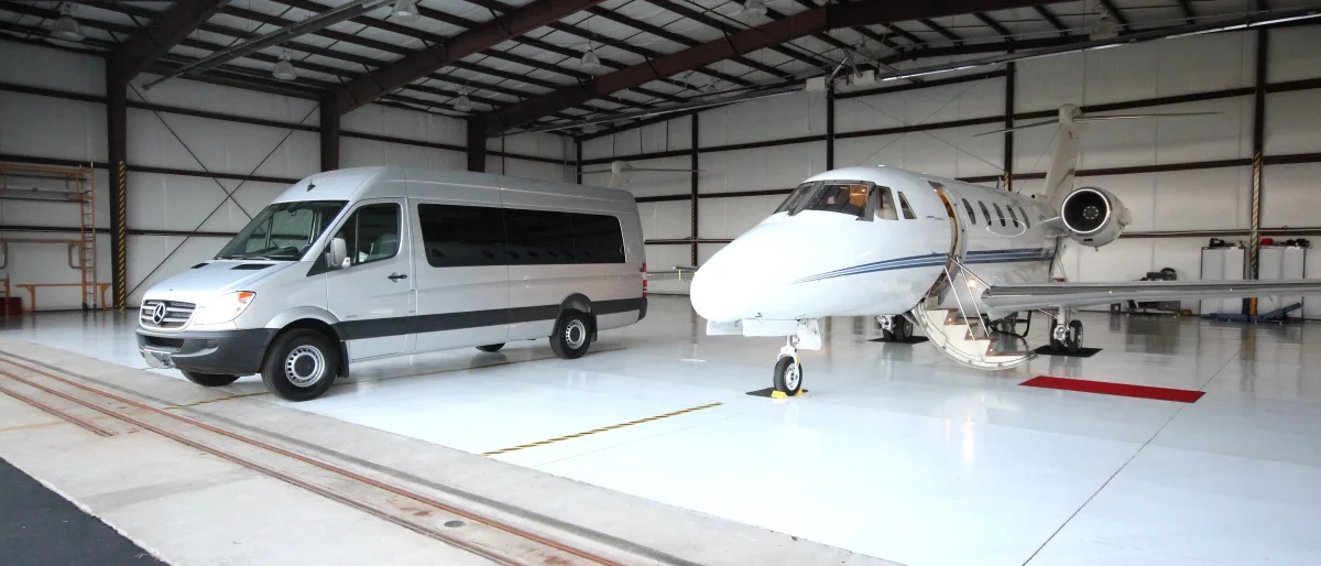 ACC Medlink Sprinter parked beside a private jet inside an aircraft hangar