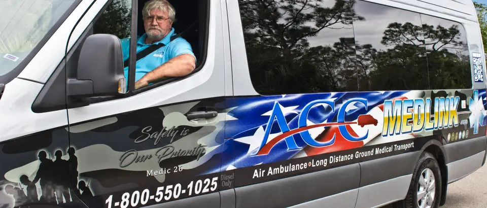 ACC Medlink driver behind the wheel of Medic 26, a Mercedes Sprinter in the ACC Medlink wrap