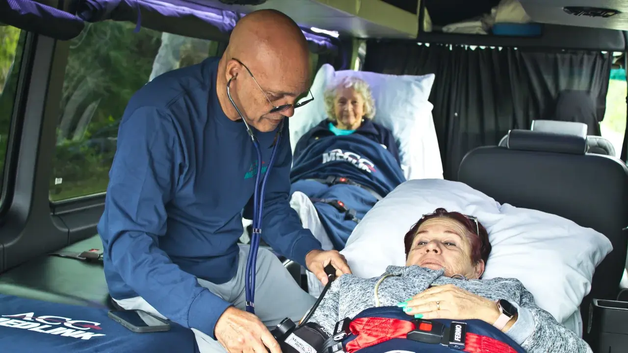 ACC Medlink medical professional checking a patient's blood pressure, with a senior patient resting nearby