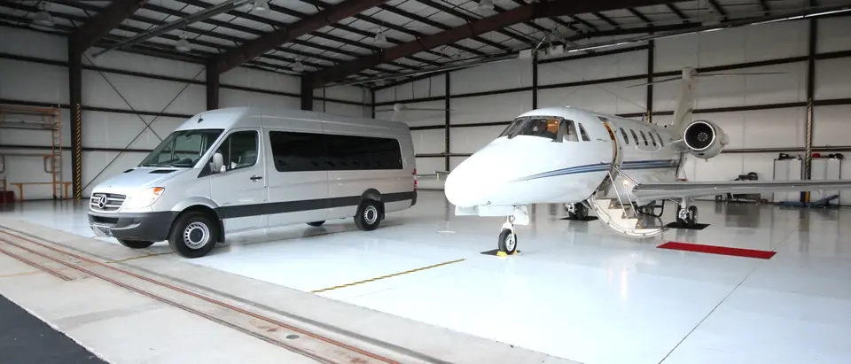 ACC Medlink Sprinter parked beside a private jet inside an aircraft hangar