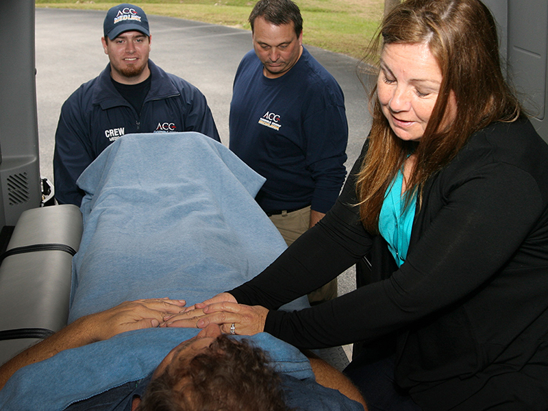 Family member sitting along-side a patient during a hospice transportation